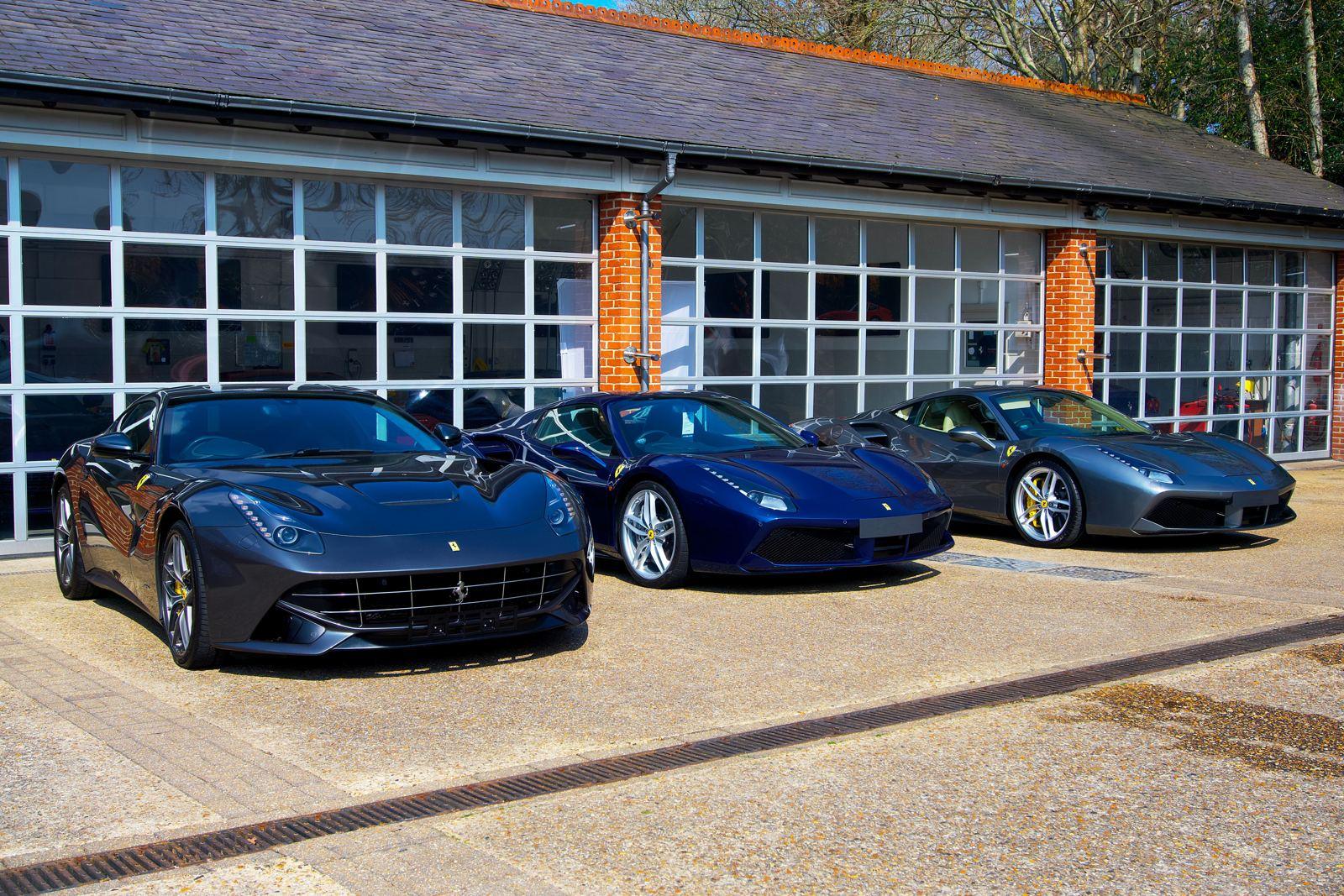 Three Ferraris parked outside a private garage