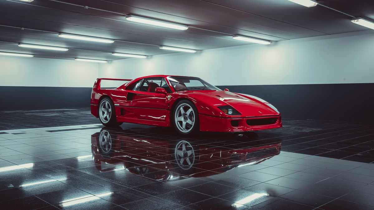 Red Ferrari F40 in a lit private garage