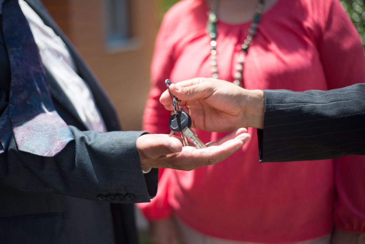 A key being handed from one person to another