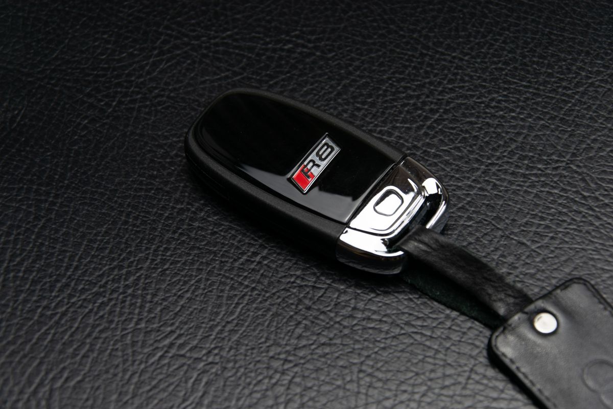 Luxury car key resting on black leather