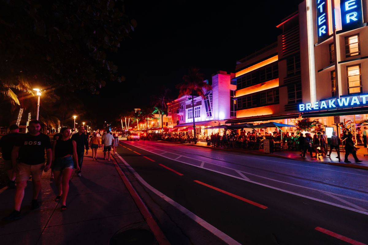 Ocean Drive in Miami Beach at night with neon-lit Art Deco hotels and evening crowds