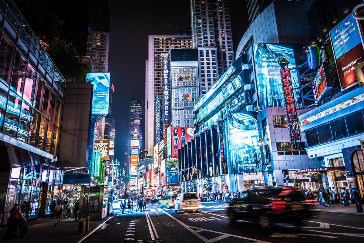 Times Square at night with illuminated billboards and traffic